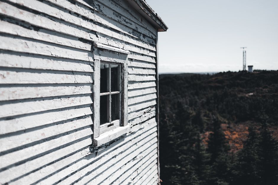 A weathered wooden house with peeling paint.