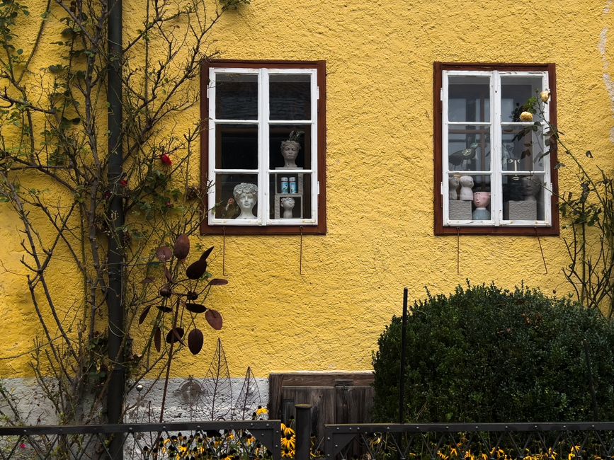 A yellow painted house front with two white-framed windows.